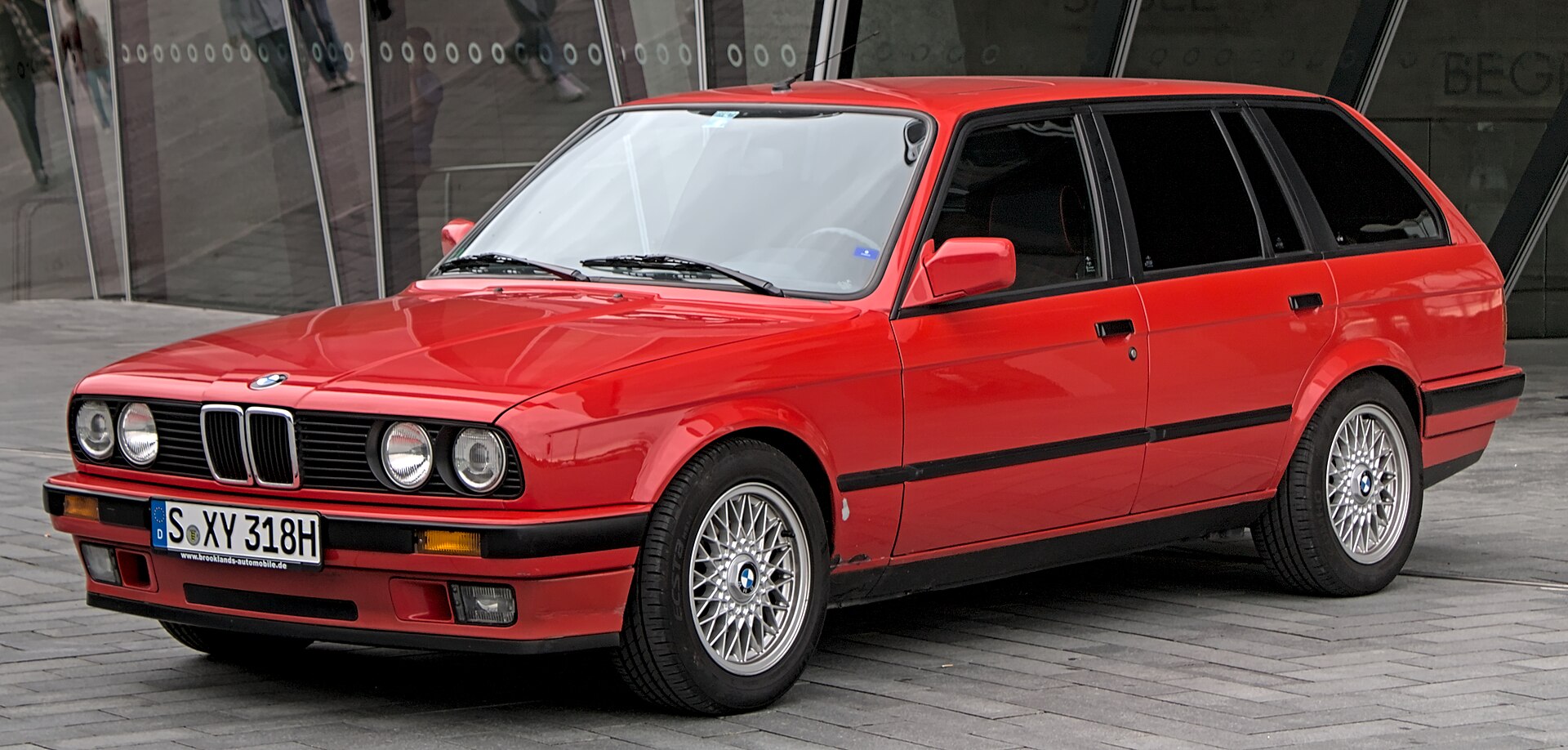 Red BMW E30 Touring photographed from the front three-quarter view