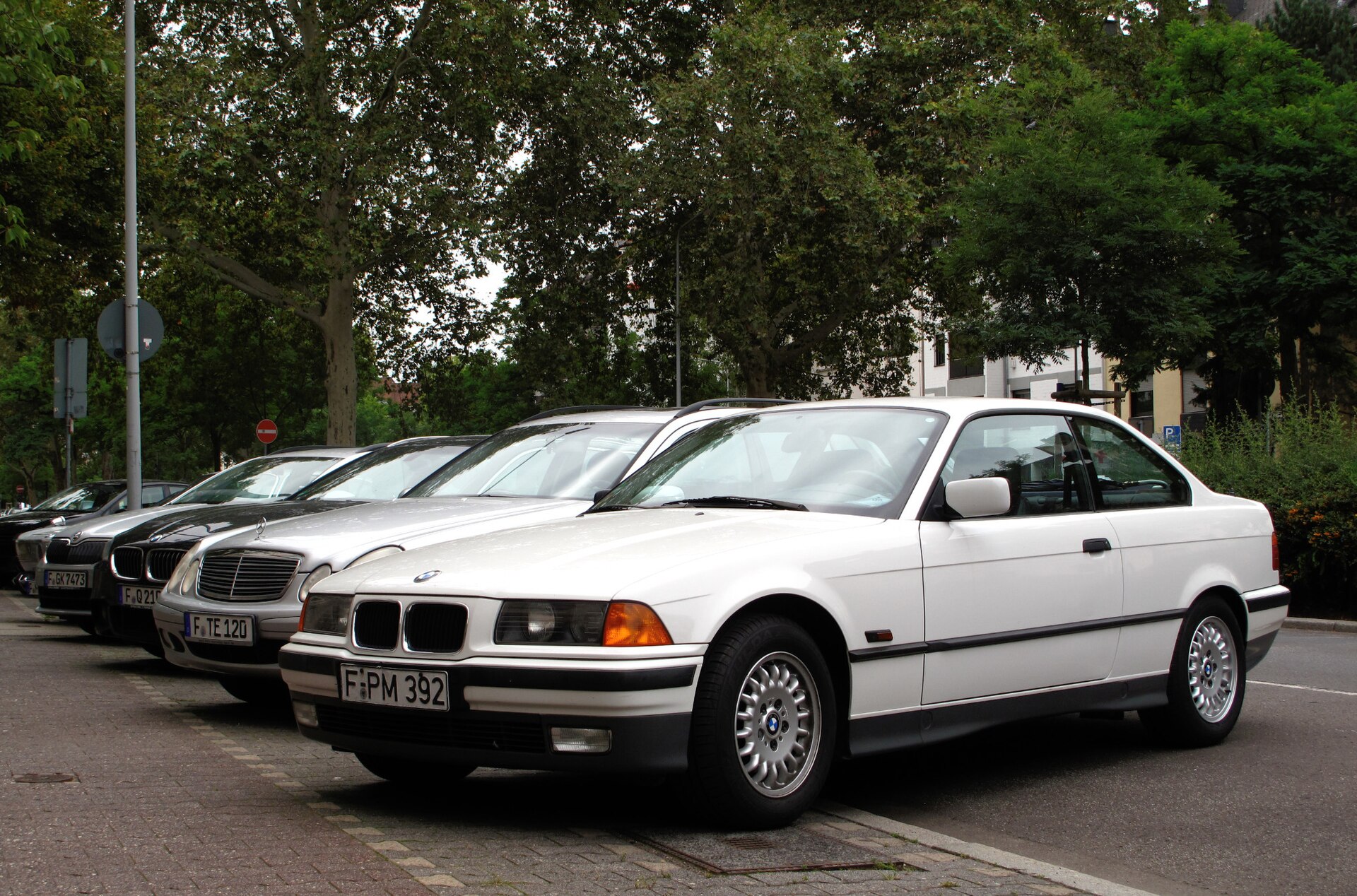 White BMW E36 Coupe photographed from the front three-quarter view