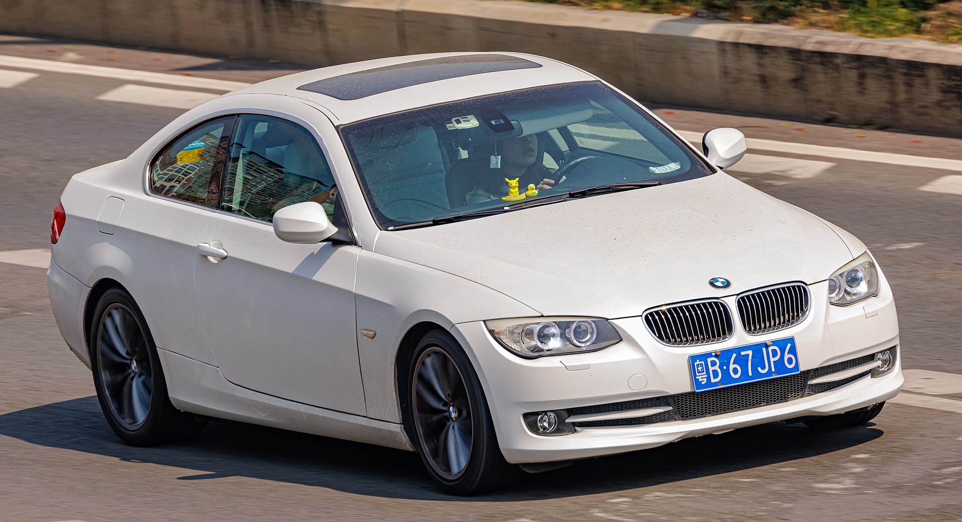 White BMW E92 Coupe photographed driving from the front three-quarter view